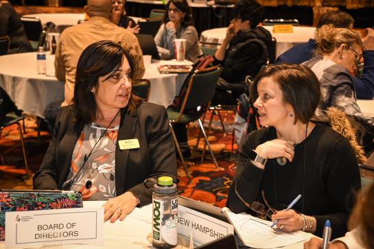 Two women discussing at a table at conference
